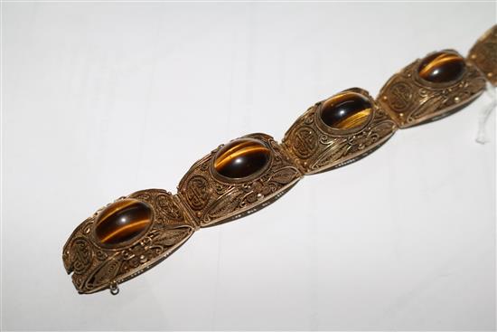 A Chinese silver gilt filligree and cabochon tigers eye quartz set bracelet, 73mm.